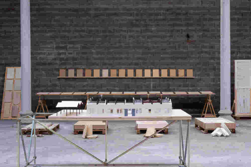 Tisch mit Modell eines Hauses in einer großen Halle