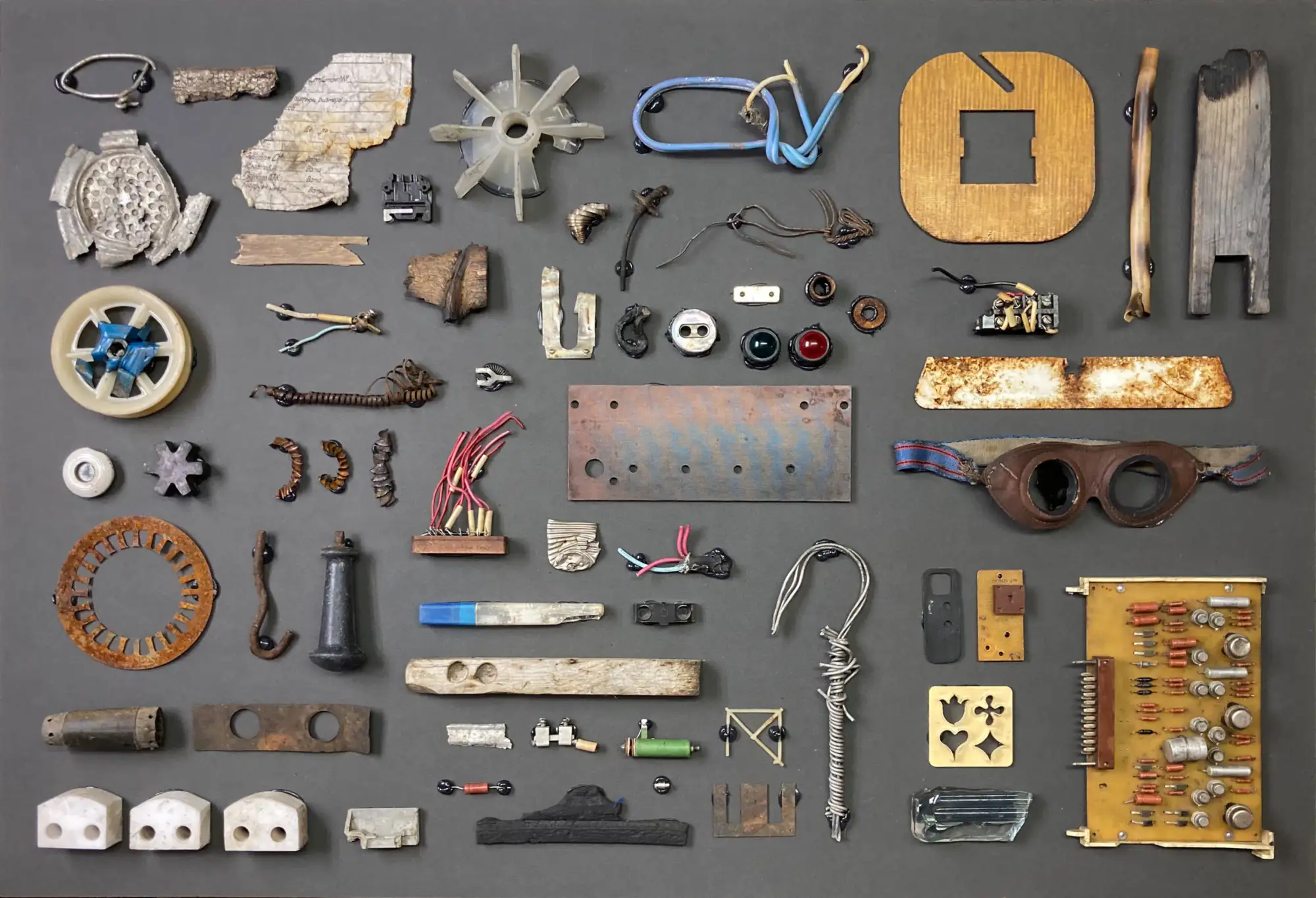 Eine Ansammlung von verschiedenen Metallgegenständen und Bauteilen, die auf flacher Oberfläche geordnet liegen