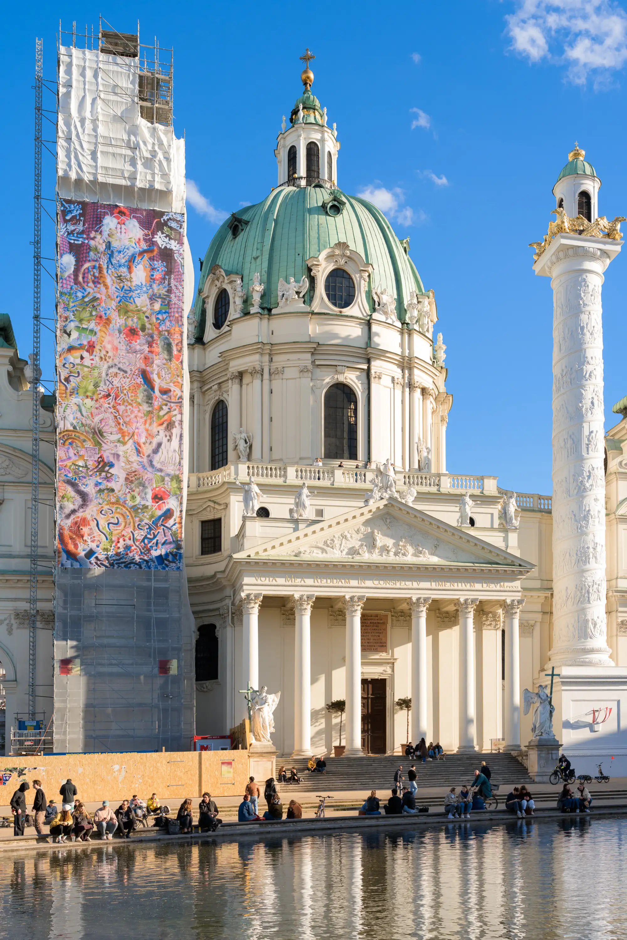 Baugerüst eineghüllt in eine Plane auf der ein Kunstwerk zu sehen ist