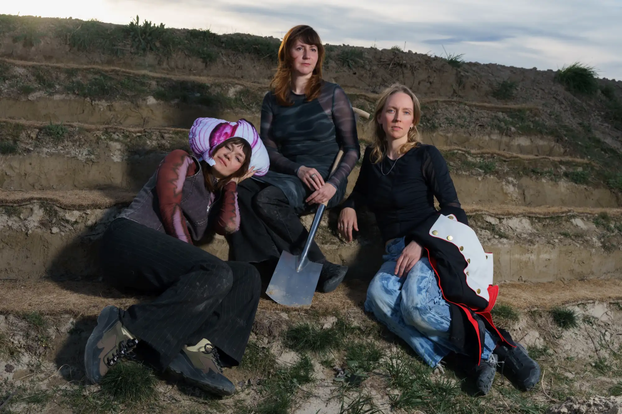 Drei Frauen auf Erdstufen sitzend.