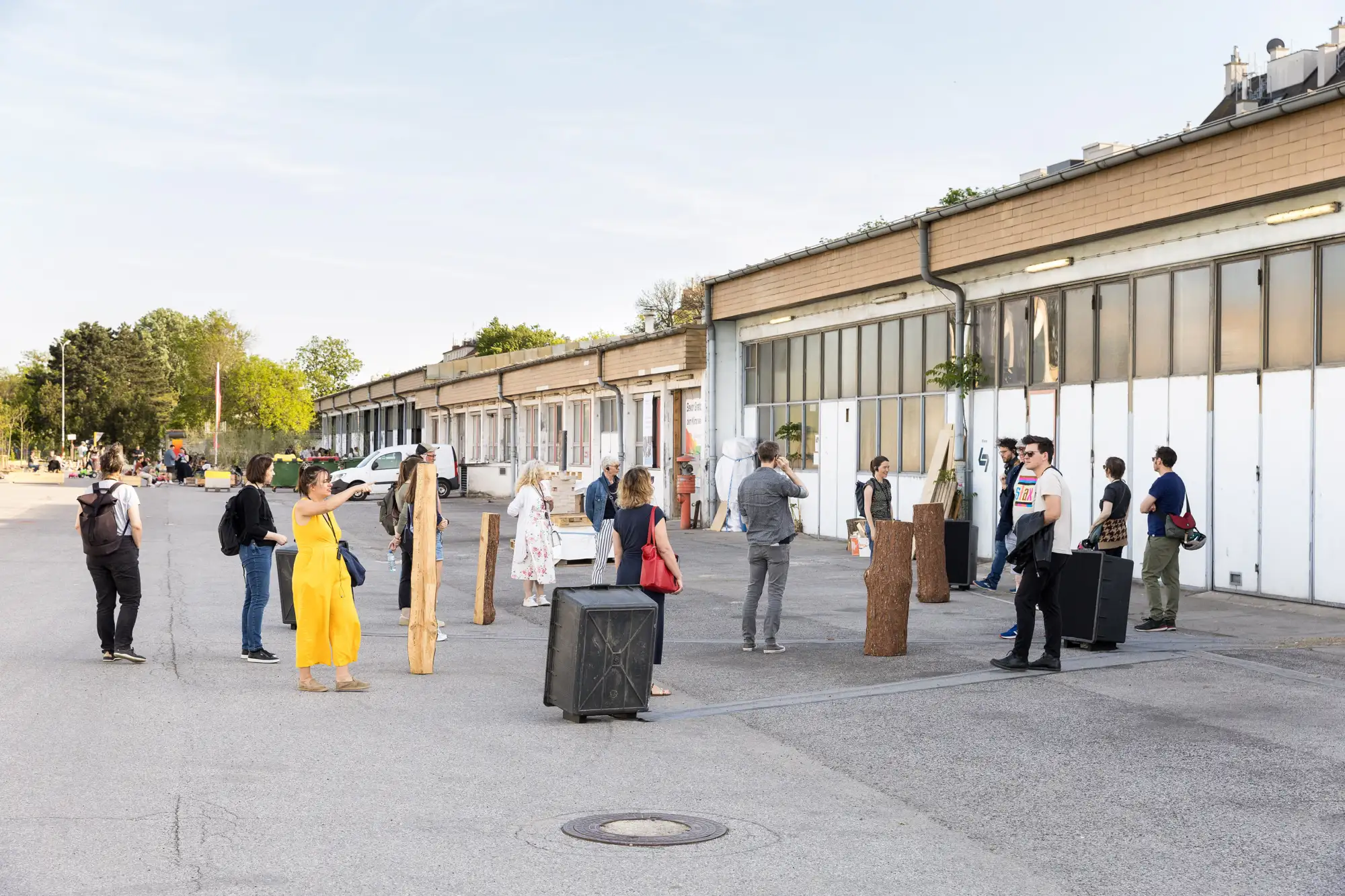 Menschen stehen vor einer Industriehalle