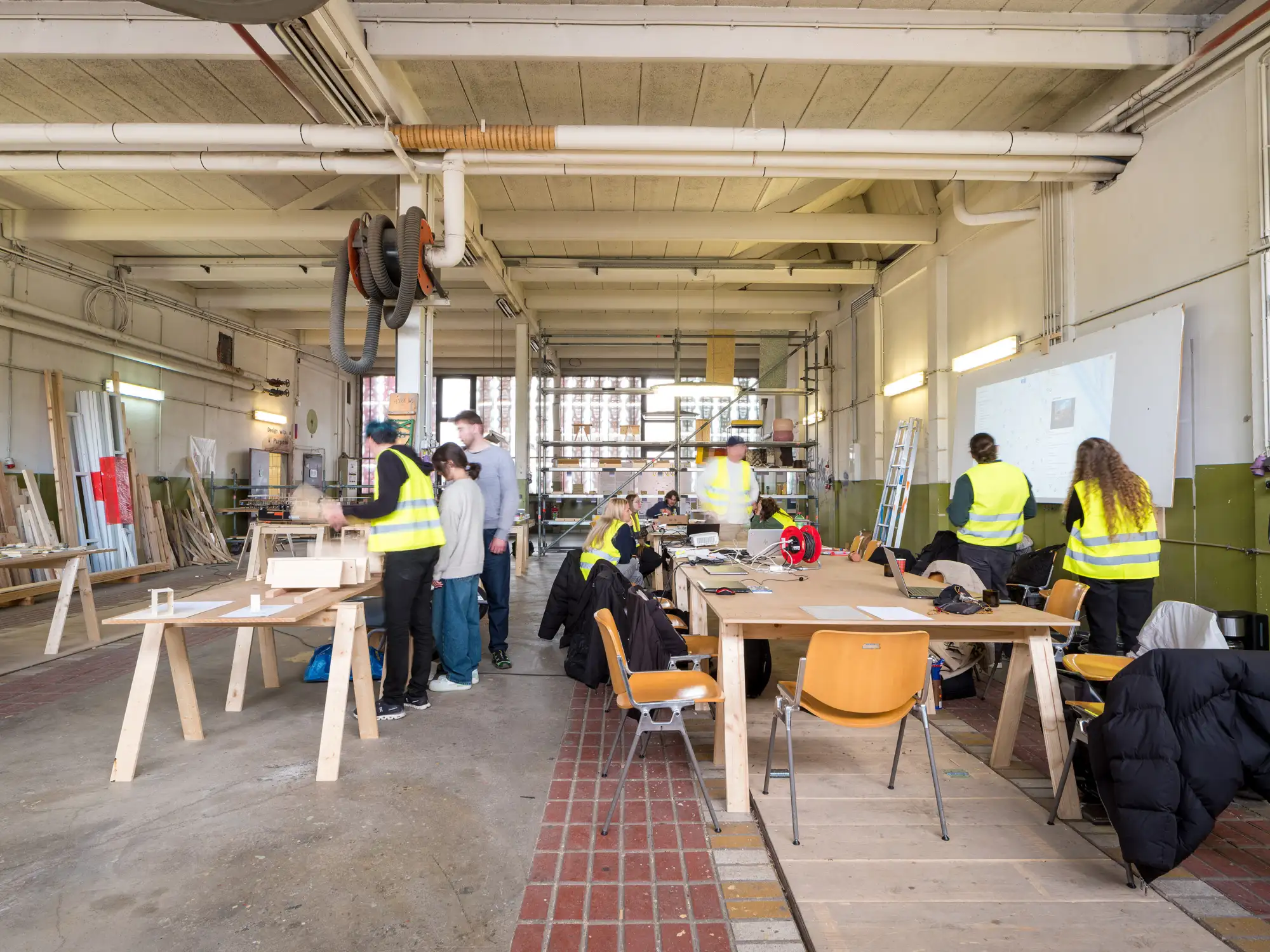 Einblick in eine Werkstatt in der Menschen an Tischen mit Samen arbeiten