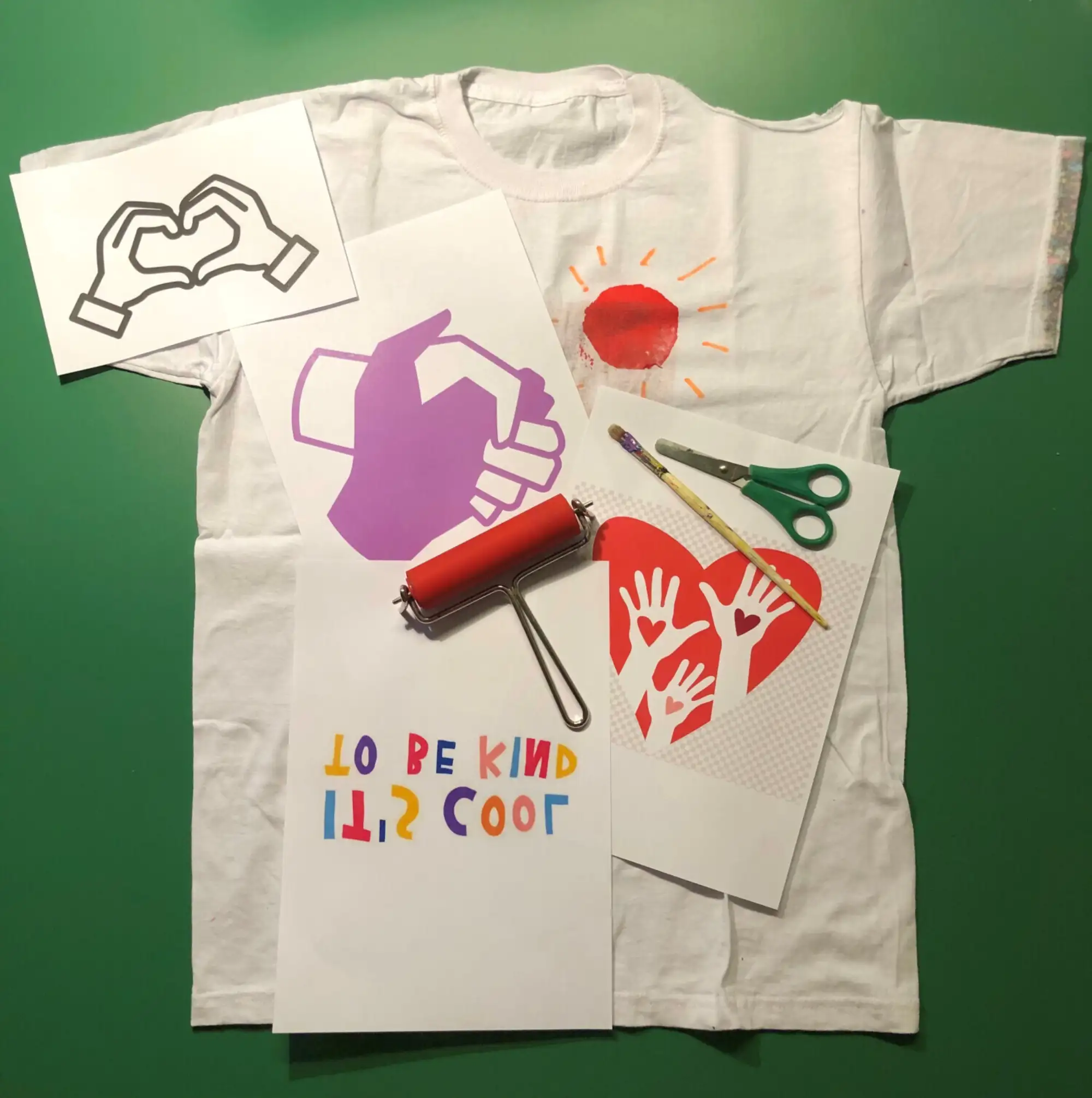 T-Shirt mit bunten Schablonen in Form von Händen, Schere und Farbwalze