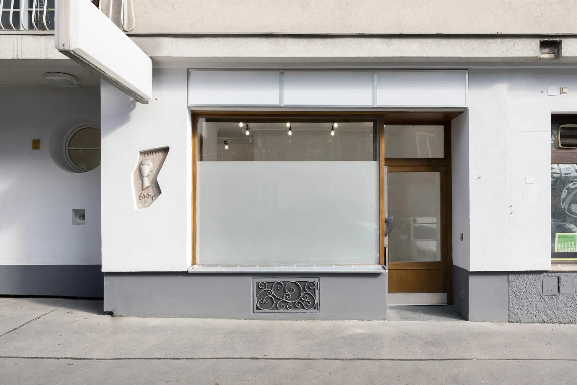 Eingangsportal aus Glas, mit weißer Fassade