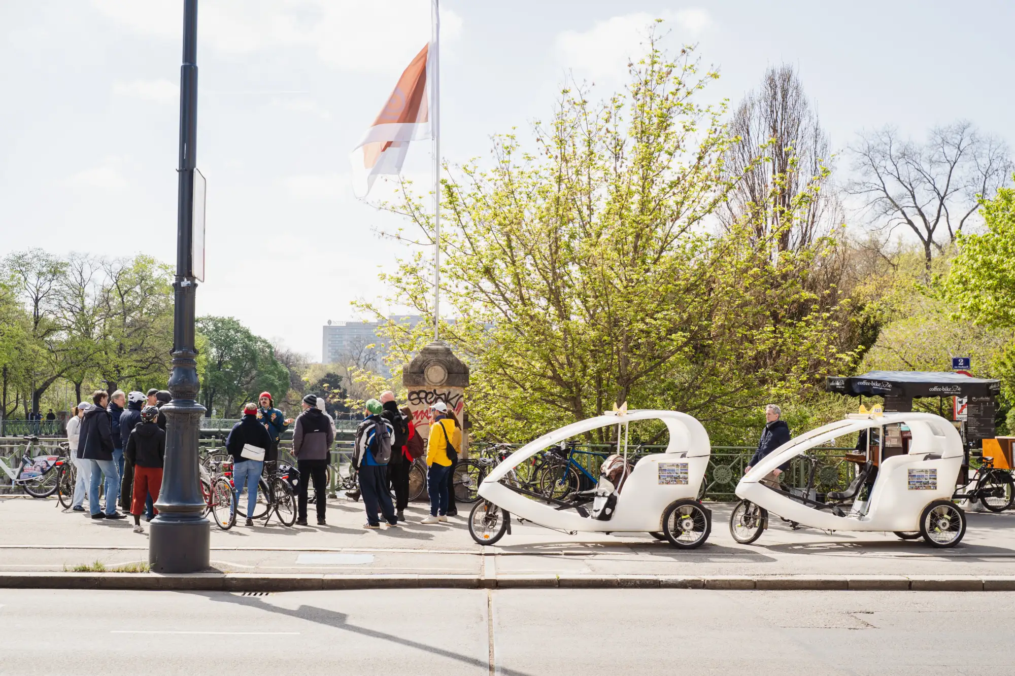 Eine Gruppe von Menschen steht mit ihren Rädern auf einer Brücke